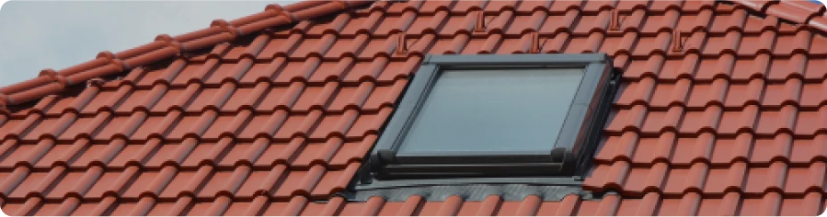 Instalación de ventanas Velux en tejado inclinado con tejas rojas, mejorando la ventilación y la luz natural en viviendas de Alcalá de Henares