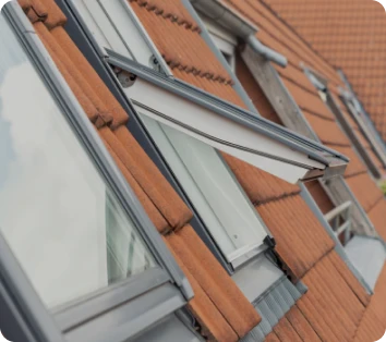 Instalación de ventanas Velux en tejados inclinados con tejas rojas, optimizando la ventilación y la luz natural en viviendas de Alcalá de Henares