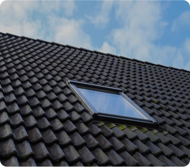 Instalación de ventanas Velux para tejados inclinados de tejas negras, mejorando la ventilación y luz natural en Alcalá de Henares.