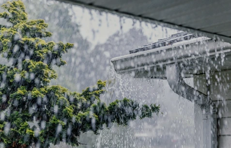 Tejado con canalón durante una tormenta, mostrando la importancia de la instalación de ventanas Velux para tejados en mejorar la protección y ventilación