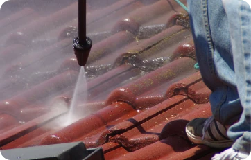 Trabajador limpiando un tejado antes de la instalación de ventanas Velux para tejados, asegurando una correcta preparación de la superficie
