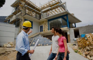 Rehabilitación de fachadas 10 Tejados Alcala Henares Arquitecto mostrando a los propietarios el avance en la rehabilitación de fachadas de una casa moderna, mejorando la estructura y estética del edificio