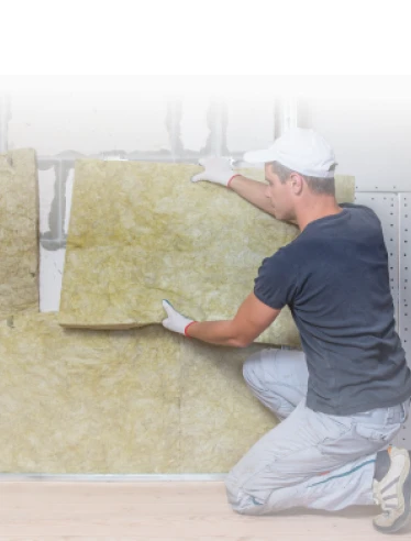 Rehabilitación de fachadas 16 Tejados Alcala Henares Trabajador instalando aislamiento térmico en una fachada como parte de la rehabilitación de fachadas, mejorando la eficiencia energética del edificio