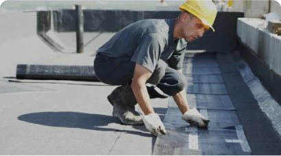 Impermeabilizaciones 10 Tejados Alcala Henares Trabajador aplicando una membrana impermeabilizante en el techo de un edificio, como parte de un proceso de impermeabilizaciones para evitar filtraciones