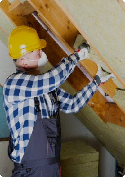 Aislamiento Térmico y Acústico 17 Tejados Alcala Henares Trabajador con casco instalando aislamiento térmico y acústico en el techo de un ático, mejorando la eficiencia energética y el confort del hogar