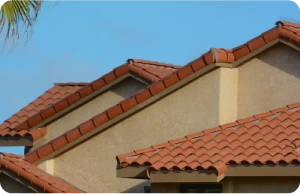 Reparación de Goteras 2 Tejados Alcala Henares Tejado de tejas rojas en una casa residencial, destacando la necesidad de mantenimiento y reparación de goteras para proteger la estructura del hogar