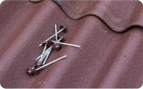 Instalación de Onduline Bajo Teja 3 Tejados Alcala Henares Clavos sobre una hoja de onduline para instalación de onduline bajo teja en tejados, mostrando detalles del material de construcción